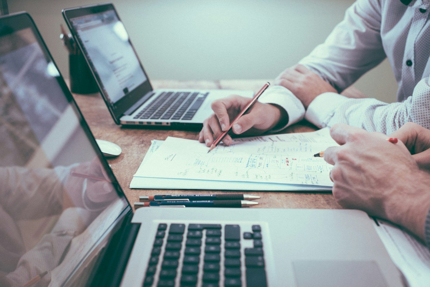 Hands reviewing documents and financial charts at a desk